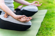 © Iryna - Practicing yoga meditation on green mat in tranquil outdoor setting