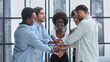 © Katsiaryna - a group of successful business diverse people in the office stands embracing