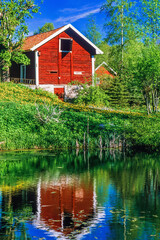 Wall Mural - Red cottage on the shore of a lake