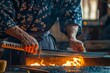 © Hunman - Master craftsman sharpening katana blade in traditional forge.