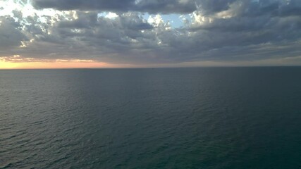 Wall Mural - Drone serene seascape view with dramatic cloudy sky at sunset at Coogee Beach in Perth, Australia