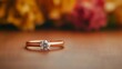© medalinebow - Elegant diamond engagement ring with gold band on wooden surface and blurred flowers