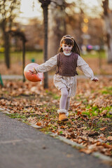 Wall Mural - little girl playing in autumn park