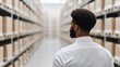 © Thitiwadee - Supply Chain Security concept. Man in a warehouse looking at shelves of boxes.