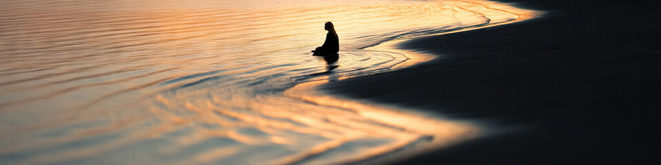 Wall Mural - Silhouetted Person at Sunset Shoreline