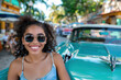© Degimages - Person in retro sunglasses casually leans against a vintage car, looking confident under sunlight