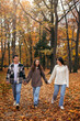 © ADDICTIVE STOCK - Family Walking Through Autumn Leaves in Scenic Park