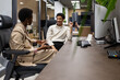 © ADDICTIVE STOCK - Colleagues Engaged in Friendly Office Conversation