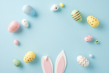 Wall Mural - colorful pastel easter eggs arranged around pink bunny ears on a soft blue backdrop