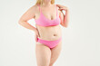 © staras - Fat woman in pink underwear on gray background, overweight female, obesity body, weight loss concept