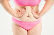 © staras - Tummy tuck, flabby skin with stretch marks on a fat belly, plastic surgery concept on gray background