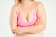 © staras - Fat woman in pink bra with large natural saggy breasts after breastfeeding on gray background, overweight female obesity body, weight loss concept