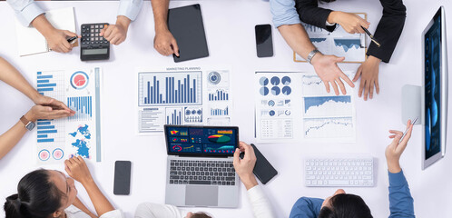 Poster - Top view analyst team utilizing BI Fintech to analyze financial data at table in meeting room. Analytic BI dashboard power on paper for business insight and strategic marketing planning. Prudent