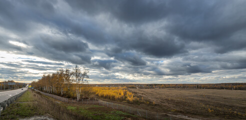 Wall Mural - a cloudy sky with a road in the background