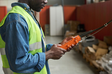 Poster - Hands of young male modern factory worker using control pad while working with industrial equipment in warehouse