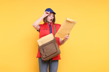 Poster - Surprised postwoman with bag and envelopes on yellow background