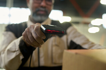 Leinwandbilder - Focus on hand of warehouse manager scanning barcodes on packed cardboard boxes while checking information