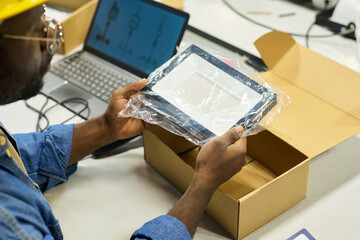 Poster - Hands of young male engineer holding new electric item in transparent packet before putting it in cardboard box