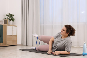 Wall Mural - Woman training with resistance band at home