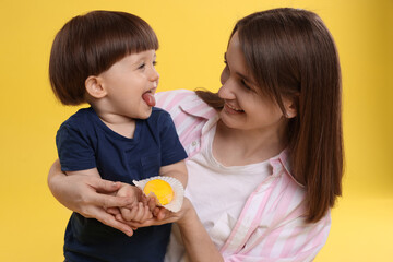 Canvas Print - Mother and baby eating tasty mochi on yellow background