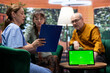 © DC Studio - Elderly man and woman talking to nurse at their home with a green screen on tablet, having a fun chat together and asking for guidance. Senior couple feeling good, relaxing at checkup visit.