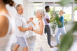 © JackF - Group of multinational sports aged people rehearsing social dance in dance hall