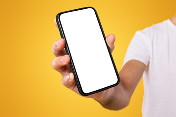 Wall Mural - Mobile Application Ad. Close Up Of Man Showing Smart Phone Empty Screen Recommending App Standing On Yellow Orange Studio Background. Isolated Transparent Cellphone Display Mock Up, Check This Website