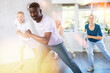 © JackF - Energetic African American man practicing hip-hop movements during adult group dance class in studio