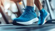 © Tcukimay - Close-up of man's feet in blue running shoes on a treadmill.
