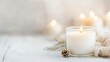 © Generative AI - Elegant White Candle with Gentle Flame Surrounded by Cozy Pinecones : Generative AI