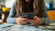 © Julia - Female Student using smartphone to check personal finances