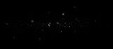 small floating dust particles in black space, glowing white specks with soft blur, abstract overlay texture, airborne microscopic elements in motion, delicate atmospheric effect