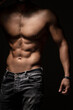 © Hamid - Muscular man's torso with detailed abs and chest against a dark background, lit dramatically