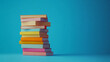 © Zahid - A stack of books on a blue background, neatly arranged to symbolize education, knowledge, literature, and learning in a clean studio setting