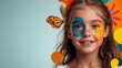 © Trushchenko_O - Young girl with blue and yellow face paint and butterflies on her face. She is smiling and looking at the camera