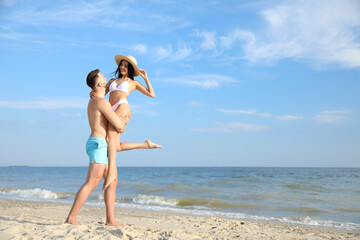 Wall Mural - Happy young couple having fun on beach