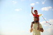 © New Africa - Happy father and his child playing with kite on sunny day. Spending time in nature