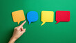 © Екатерина Чумаченко - Colorful speech bubbles arranged on a green background, conveying communication, feedback, or ideas. A hand points to the first bubble.