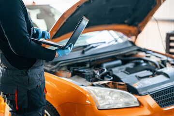 Poster - Serviceman with laptop checks car software in car service