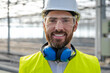 © zinkevych - Smiling caucasian bearded engineer in protective glasses at the construction site
