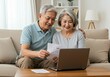 © Everyday Frame - Senior couple managing finances online at home.