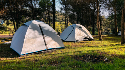 modern camping tents in the forest on a sunny day. adventures camping tourism and tent under view pi