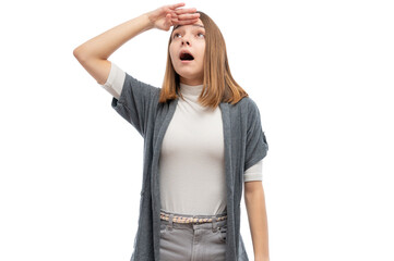 Wall Mural - A young woman with straight hair looking surprised and shielding her eyes against a white background.