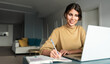 © Stock 4 You - Young smiling IT student woman working on laptop pc at home remotely. Latin freelance businesswoman entrepreneur using computer AI app for online remote business studying watching webinar. Copy space