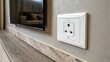 © DigitalSpace - A closeup of a socket outlet cleverly installed within the wall with no visible wires illustrating a seamless integration for powering the TV.