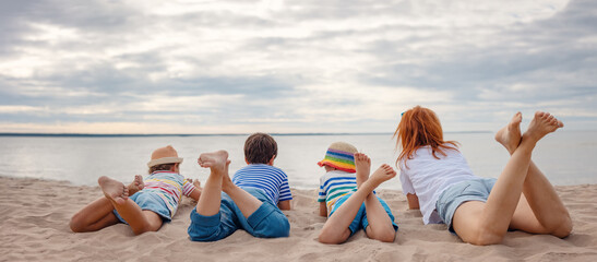 Wall Mural - Group of for people lying on the sunny sand beach.