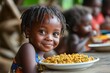© Gatherina - Smiling young african girl enjoying a nutritious meal at school cafeteria