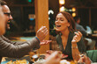 © djile - Man feeding woman delicious meal with fork while enjoying romantic dinner at restaurant