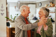 © Rido - Loving senior couple dancing at home with joy