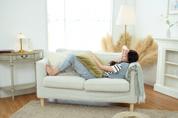 Wall Mural - Young Asian woman relaxing in living room at home